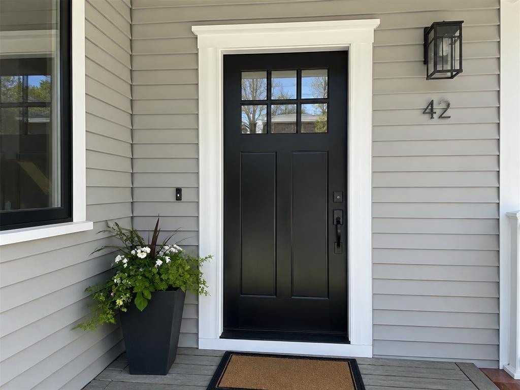 Black craftsman front door with white trim casing